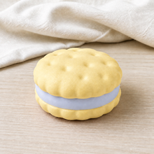 Real product photo of the NOLLUMI Sandwich Cookie Squishy in Sunshine Yellow on ivory linen and light wood
