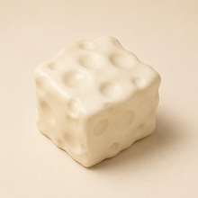 NOLLUMI Tiny Cheese Squishy, an ivory cream cube with softly rounded edges and irregular cheese dimples